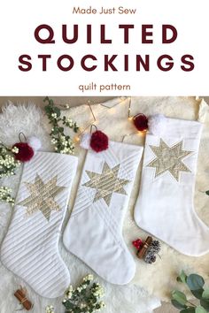 three christmas stockings with gold stars and pom poms hanging from them on a white blanket