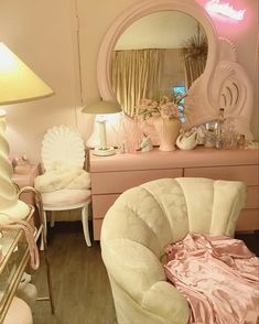 a bedroom with pink furniture and accessories on the floor, along with a large mirror