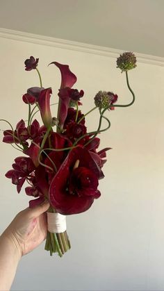 a person holding a bouquet of flowers in their hand