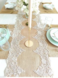 the table is set with white flowers and place settings