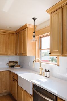 a kitchen with wooden cabinets and white counter tops, along with a dishwasher