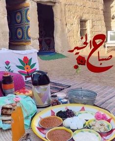 a table topped with lots of food on top of a wooden table next to a building