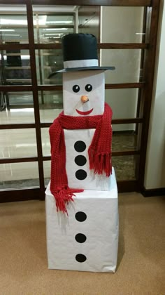 a cardboard snowman made to look like it is wearing a top hat and scarf