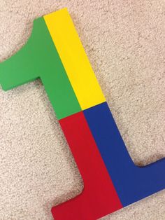 the letter j is made out of cardboard and painted in bright colors, sitting on carpet