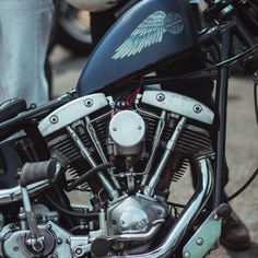 a close up of a motorcycle engine with wings on it's front wheel and the handlebars