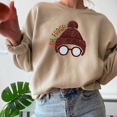 This 'Oh Fudge' sweatshirt is inspired by a Christmas story, perfect for cozying up during the holiday season. It gives off a festive and nostalgic vibe, making it a great addition to your winter wardrobe. The unisex design is suitable for anyone looking for a comfortable and stylish sweatshirt to wear during Christmas celebrations. DETAILS: Printed on a super soft, cozy Gildan hoodie sweatshirt. Made with a thick blend of cotton and polyester, it feels plush, soft and warm, a perfect choice for any cold day. FABRIC:  50% cotton, 50% polyester, Made from specially spun fibers that make for a very strong, smooth fabric. Polyester fibers are extremely resilient, resistant to most chemicals, stretching, and shrinking. Heather Sport colors are 40% Cotton, 60% Polyester SIZING GUIDELINES: This Fudge Christmas, Quote Sweater, Oh Fudge, Xmas Movies, Movie Quote, Funny Holiday, Gildan Hoodie, Christmas Story, Sweater Gift