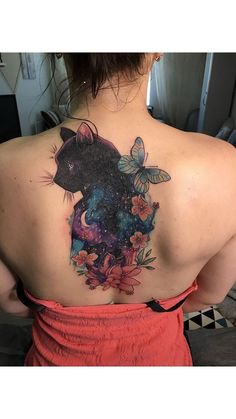 the back of a woman's shoulder with a cat and butterfly tattoo on it