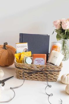 a basket filled with lots of different items next to some pumpkins and other decorations