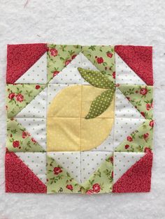 a piece of quilted material with an apple on the top and green leaves on the bottom