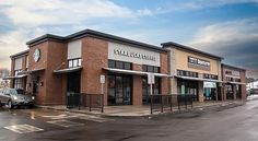 a starbucks coffee shop sitting on the side of a road next to a parking lot