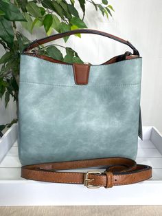 Get ready to take on the day with the Tati Hobo Satchel in Teal! This hobo bag features a magnetic snap closure for easy access, along with zip and inner slip pockets for all your essentials. Slay all day with this stylish and practical bag! Adjustable and detachable shoulder strap Two inside compartments Vegan leather Dimensions: 11'' L x 4.25'' D x 10.5'' H Slay All Day, Practical Bag, Online Clothing Boutiques, Leather Hobo Bag, Women Helping Women, Leather Hobo, Hobo Bag, Easy Access, Boutique Clothing