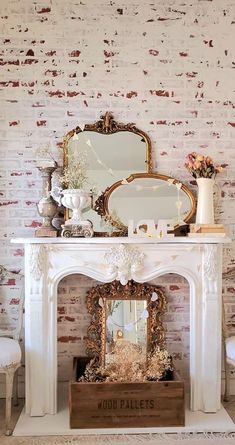 a fireplace with a mirror, vases and other items on it in front of a brick wall