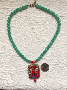 "Up for your consideration is a Vintage Cloisonne Pendant Necklace with Green Jade Peking Glass and Red Bakelite Beads. This necklace measures 17 1/2\" long and the pendant measures 2\" x 1 1/4\". If you have any questions, please don't hesitate to e-mail me and be sure to check out my other items for sale. Thanks for looking." Green Beaded Rectangular Necklace, Green Rectangular Beaded Necklace, Spiritual Red Jade Jewelry, Green Rectangular Beaded Necklace Gift, Rectangular Green Beaded Necklace For Gift, Red Amulet Beaded Necklaces With Colorful Beads, Multicolor Beaded Jade Necklaces, Multicolor Beaded Jade Necklace, Multicolor Jade Beaded Necklaces