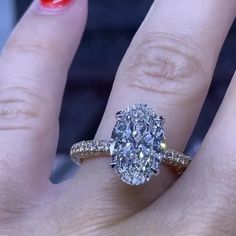 a woman's hand with a ring on it and a diamond in the middle