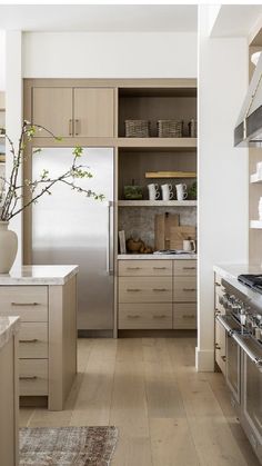 a kitchen with wooden floors and stainless steel appliances