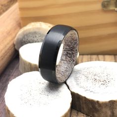 two wooden slices are stacked on top of each other with a black ring in the middle