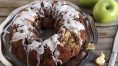 a bundt cake sitting on top of a plate next to an apple