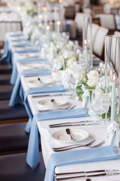 the table is set with silverware and blue napkins