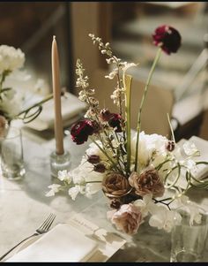 the table is set with flowers and candles