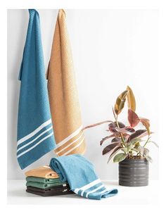 towels and potted plant on white surface