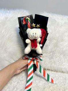 a teddy bear in a gift box with candy canes