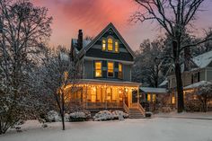 a house is lit up at night in the snow