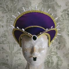 This royal Tudor inspired headdress is covered with silk shantung in either purple (pictured) or black.It is embellished with golden cord trimming all around the edges.It is further trimmed with pearl bead details that create a halo effect. The piece is completed with a beautiful crystal and pearl handmade element at the center front. The base is a headband style, completely handmade to be able to support the shape and design of the headdress. The adjustable elastic, that goes under the hair at Fitted High Crown Costume Hats And Headpieces, Fitted Costume Hat With Tall Crown, Fitted Tall Crown Costume Hats, Fitted Tall Crown Costume Hat For Costume Party, Fitted Tall Crown Costume Hats And Headpieces For Parties, Fitted Tall Crown Headpiece For Costume Party, Fitted Crown Headpiece For Costume Party, Gothic Fitted Headpiece For Festival, Gothic Fitted Festival Headpieces