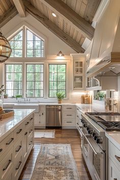 a large kitchen with white cabinets and wood floors, an area rug on the floor