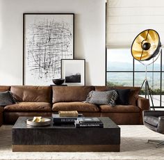 a living room filled with furniture and a large window covered in shades of white, brown and black