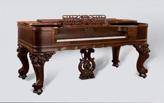 an old wooden piano sitting on top of a table