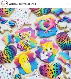 colorful decorated cookies are displayed on a white surface with stars and other items in the background