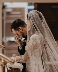 the bride and groom are talking on their cell phones in front of the alter at the church