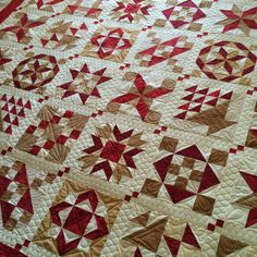 a red and white quilt with many different designs on it's sides, including stars