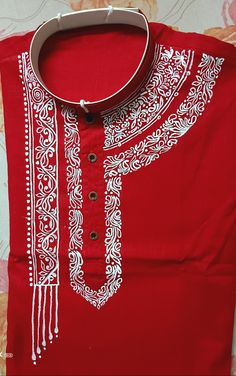 a red shirt with white embroidery on it