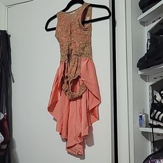 there is a dress hanging on a rack in the closet next to shoes and purses