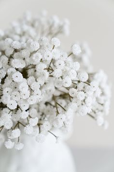 a white vase filled with flowers on top of a table