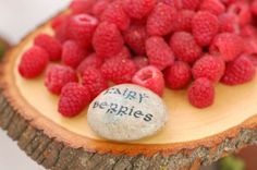 some raspberries are sitting on top of a piece of wood