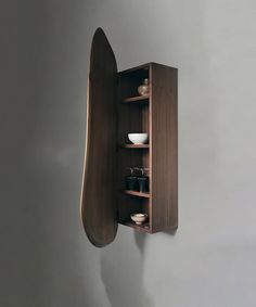 a wall mounted wooden shelf with dishes on it