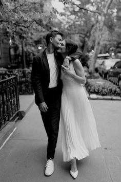 a man and woman kissing on the street