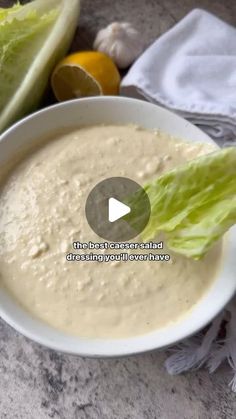 a white bowl filled with soup next to lettuce