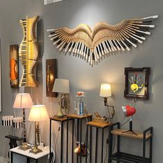 a room filled with lots of different types of lamps and decor on display in front of a gray wall