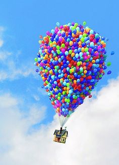 a house is floating in the air with balloons