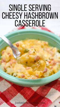 a green bowl filled with cheesy hashbrown casserole on top of a red and white checkered table cloth