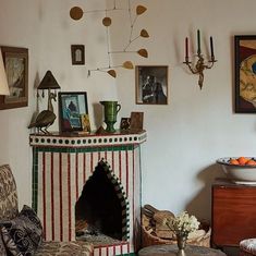 a living room filled with furniture next to a fire place and pictures on the wall