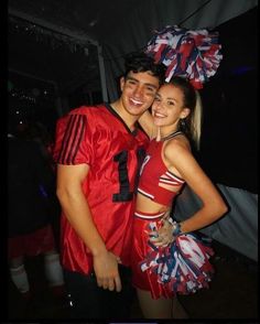 a man and woman dressed up in cheerleader outfits posing for a photo at a party