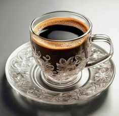 a cup of coffee sitting on top of a glass saucer