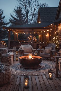 a fire pit sitting on top of a wooden deck surrounded by chairs and lights at night