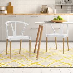 two white chairs sitting at a table in a kitchen