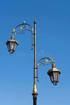 an old fashioned lamp post with two street lamps on it against the blue sky royalty images