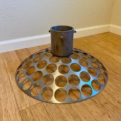 a pot holder sitting on the floor in front of a wall